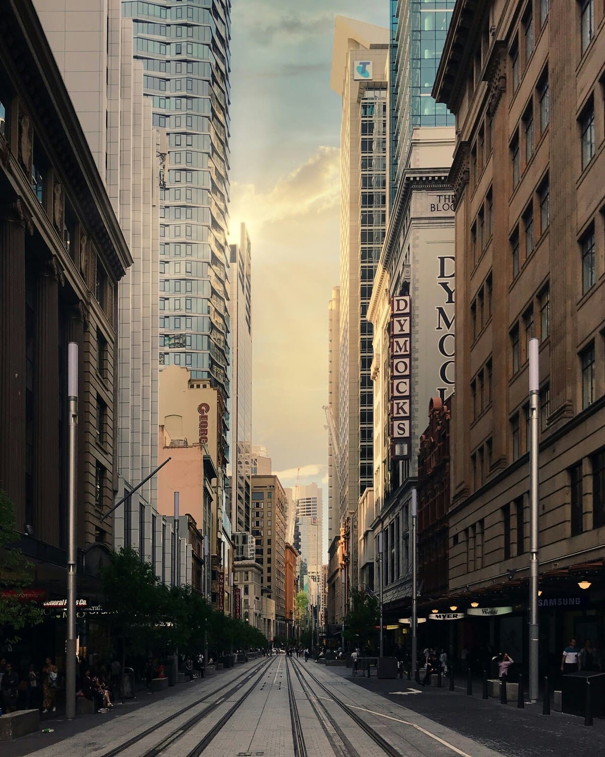 The city breathes through a veil of distant fire.